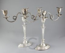 A pair of George V silver two branch, three light oval candelabra by Barker Brothers, with scrolling