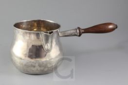 A large 18th century? silver bulbous saucepan with turned lignum vitae handle, and interior spout
