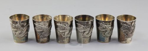A set of six early 20th century Chinese Export silver tots, each decorated with a dragon, maker IC