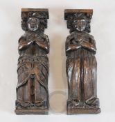 A pair of 18th century carved oak corbels, framed as figures standing with crossed arms, 14.5in.