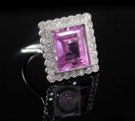 A 18ct white gold, synthetic pink sapphire and diamond cluster dress ring, the rectangular cut stone