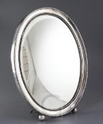 An early 20th century Portuguese 833 standard silver mounted oval easel mirror, with decorated