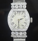A lady's 1950's white gold and diamond set cocktail watch, with tonneau shaped Arabic dial and