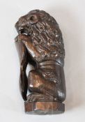 An early 18th century carved lion sejant, modelled holding a shield, 10.5in.