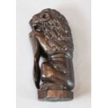 An early 18th century carved lion sejant, modelled holding a shield, 10.5in.