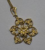 An Edwardian 18ct and 15ct gold, seed pearl flower head pendant, on an 18ct gold fine link chain,