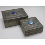 Two Arts & Crafts style pewter-covered wooden boxes, each with blue enamel oval cabochon to cover,