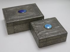 Two Arts & Crafts style pewter-covered wooden boxes, each with blue enamel oval cabochon to cover,