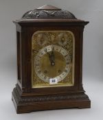 A carved oak mantel clock, with 'ting-tang' chiming movement and brass dial