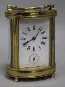A French brass oval carriage timepiece with alarm