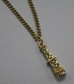 A gold charm, modelled as an oil rig, on a 9ct gold chain.