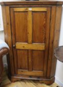 An early 19th century stripped pine corner cupboard, H.132cm