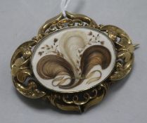 A Victorian pinchbeck brooch with central oval glazed hairwork panel in pierced and scrolled