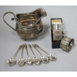 A George III silver cream jug, a Victorian silver napkin ring (cased), two other napkin rings and