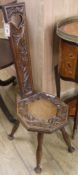 An Arts & Crafts carved oak milking stool, H.95cm