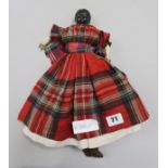 A Victorian doll wearing a tartan dress