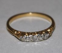 An early 20th century 18ct gold and five stone diamond half hoop ring, size M.