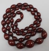 A single strand graduated simulated cherry amber bead necklace, 92cm, gross 106 grams.