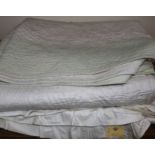 An off-white quilt with blue stitching, a reversible blue and cream quilt, a creamy oyster quilt and
