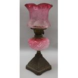 A cranberry shaded oil lamp