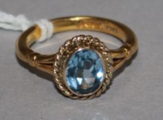 A 22ct and blue stone set oval ring, size O.