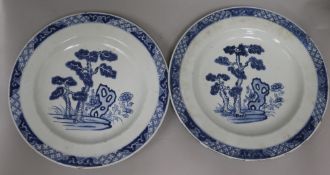 A pair of 19th century Chinese blue and white porcelain shallow dishes, each decorated with pine