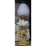 A Moore Bros white, cream and gilt porcelain oil lamp with cherub and flowering cactus support, with