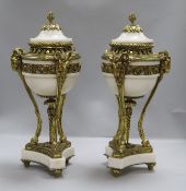 A pair of Louis XVI style white marble and gilt metal cassolettes, with rams mask headed supports,