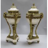 A pair of Louis XVI style white marble and gilt metal cassolettes, with rams mask headed supports,