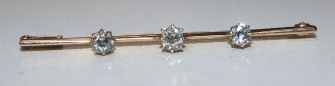 A gold and three stone diamond set bar brooch, 54mm.