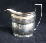 A George III silver engraved helmet shaped cream jug.