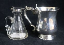 A George V silver mounted glass whisky tot jug and a George V silver christening mug.