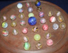 A solitaire board with 19th Century glass marbles