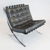 A Mies Van der Rohe Barcelona chair, with black leather upholstery and chrome frame, W.2ft 5in. H.