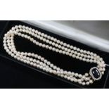 A three strand cultured pearl choker necklace, with oval sapphire and diamond set clasp, 38cm.