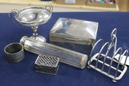 A silver five bar toastrack, a silver cigarette box, as silver pedestal nut dish and three other