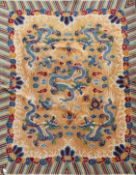 A Chinese carpet, the apricot field with five indigo dragons with a polychrome banded border,