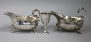 A pair of Edwardian silver sauce boats and a small trophy cup, (one sauceboat a.f.).