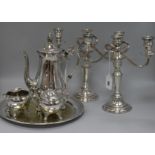 A pair of plated candelabrum, a three-piece plated coffee set, a circular tray and a dwarf