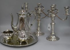 A pair of plated candelabrum, a three-piece plated coffee set, a circular tray and a dwarf