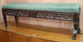 An Edwardian pierced and scroll-carved mahogany duet stool, with upholstered seat, L 55in W.140cm