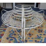 A Regency wrought iron strapwork wrap around tree bench, W.159cm