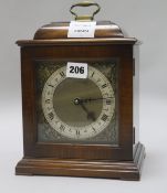 A reproduction walnut mantel timepiece