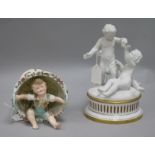 A Parianware putti table centre and a boy sitting in a basket ornament