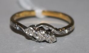 An 18ct gold, platinum and illusion set three stone diamond ring, with diamond set shoulders, size