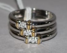 A modern 18ct white gold and three stone diamond triple band ring, size O.