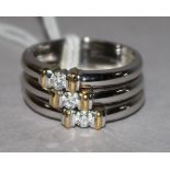 A modern 18ct white gold and three stone diamond triple band ring, size O.