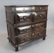 An early 18th century oak chest, of four geometric panelled long drawers, on stile feet, W.3ft