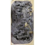 A Chinese wooden panel carved in high relief with a hunting party in a landscape, 29 x 58cm