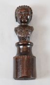 A 17th century carved oak newel post finial of a woman, on circular plinth, 11in.